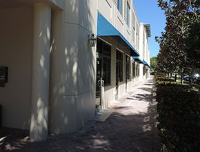 paved interconnected front porches for the executive suite offices of a business center with topiary and grass